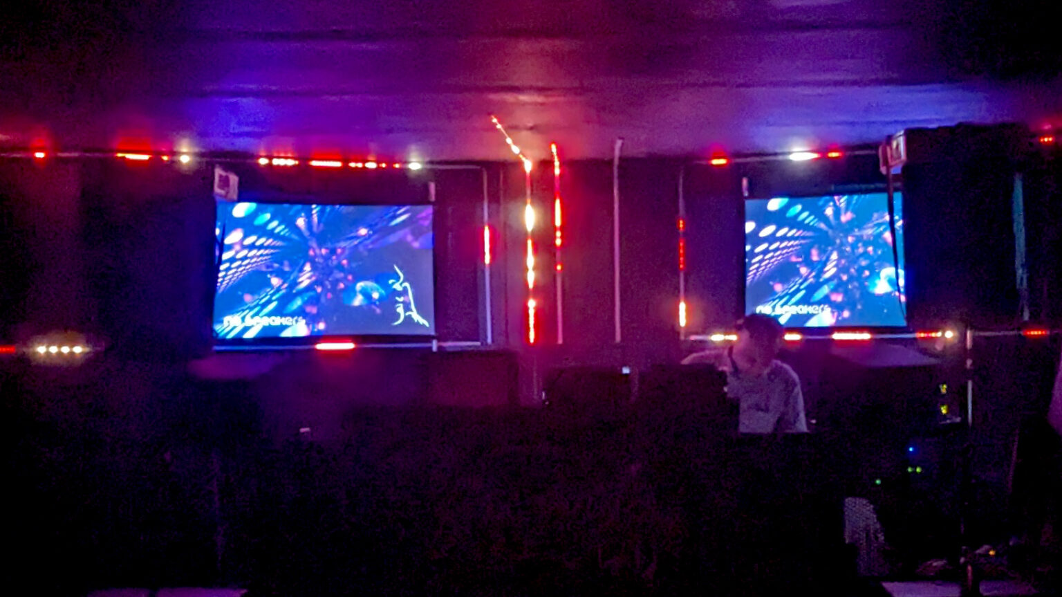 Live mixed visuals across two screens on a crowded dancefloor