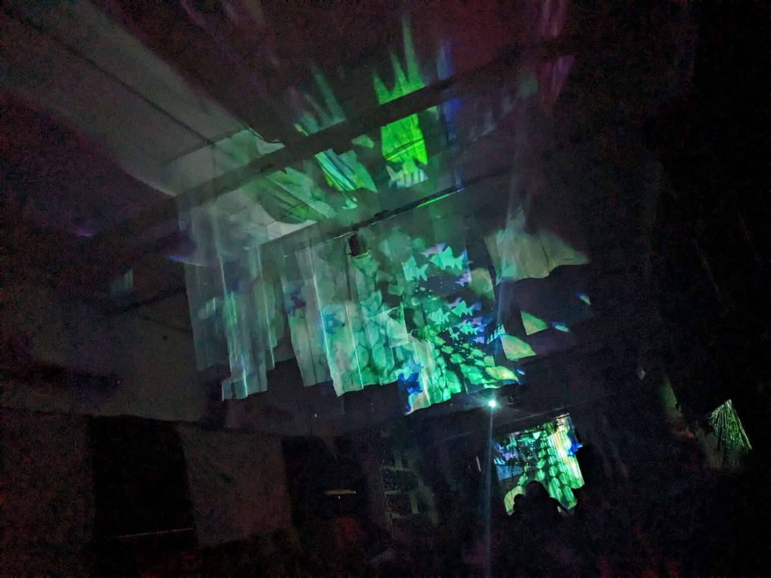 Experimental projections suspended through a dark installation space
